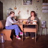 RUSSIA / St.Petersburg / June 2007 / Marina (left), a realtor, eating her breakfast with her daughter Arina. Marina and two of her three children share a 30 square meter room where they moved about a month before this picture was taken after she divorced with her husband. Most Russians like to eat in their kitchens but those who live in communal housing can not and do it in their rooms. 

© Max Sher / Anzenberger