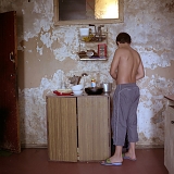 RUSSIA / St.Petersburg / July 2007 / A boy cooks in his dilapidated communal kitchen. Basically, every household in a communal flat should have a cooking table and a cupboard of their own. 

© Max Sher / Anzenberger