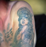 A tattoo depicting a woman in a Nazi cap showing off her breasts. During Soviet times, tattooed Nazi symbols were very popular among criminals as they symbolised their resistance against the "system".